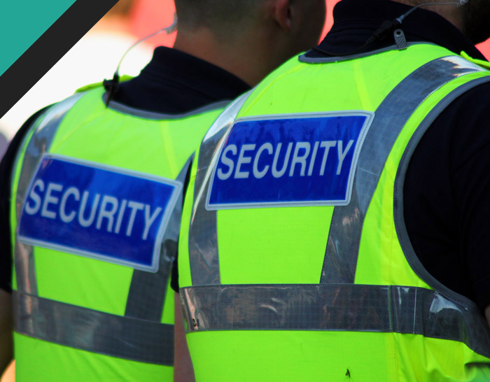 Two security personnel wearing high-visibility vests with 